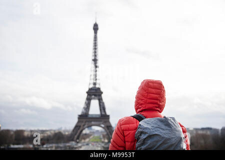 Giovane uomo con zaino guardando la torre Eiffel a Parigi, Francia Foto Stock