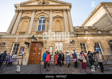 Un gruppo di turisti cinesi coda fuori l'ingresso al centro storico camere della pompa nella vasca da bagno in una giornata di sole in inverno in attesa per le porte da aprire Foto Stock