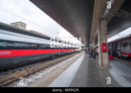 Immagine sfocata bokeh di treno presso la piattaforma, stazione ferroviaria di Venezia, Italia. Foto Stock