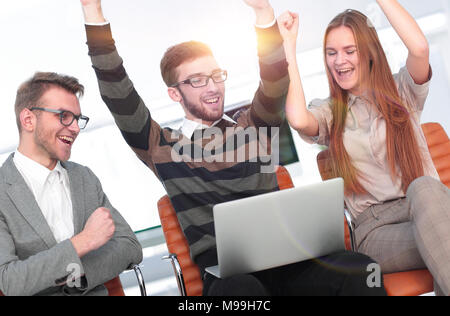 Tre dipendenti eccitati ricevendo buone notizie insieme sulla linea Foto Stock