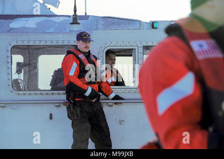 Coast Guard membri assegnati per gli Stati Uniti Stazione della Guardia costiera Valdez prepararsi a bordo di una nave civile sospettata di trasportare materiale radiologica da un satellite crash al Porto di Valdez, Alaska, durante l'esercizio Arctic Eagle 2018, Feb. 24. Arctic Eagle 2018 è una patria di sicurezza e risposta alle emergenze esercizio operando su tutto il territorio dello stato dell'Alaska, ospitato dall'Alaska Guardia Nazionale. (U.S. Esercito nazionale Guard Foto Stock