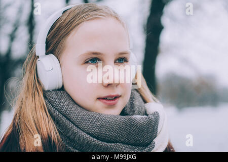 Felice ragazza l'ascolto di musica con cuffie e passeggiate all'aperto Foto Stock