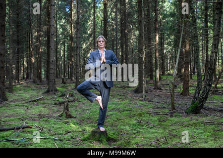 Imprenditore a praticare yoga in foresta Foto Stock