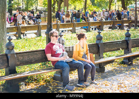 La città di New York, Stati Uniti d'America - 28 Ottobre 2017: Manhattan New York City NYC Central park con il giovane romantico incinta giovane seduto in molti caduta foglie foli Foto Stock