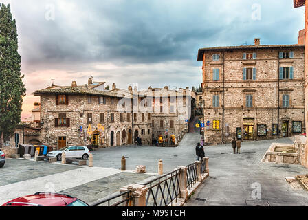 Passeggiando per le pittoresche e antiche strade di Assisi, una delle più belle città medievali in Italia centrale Foto Stock