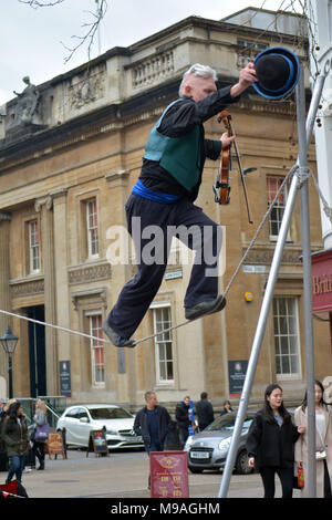 Bristol, Regno Unito. Il 24 marzo 2018. Per un pomeriggio di divertimento lungo le strade del vino Street, Bristol. Una performance di Slacklining tra due post da dalla persona che gioca un violino e abilmente mentre il bilanciamento camminando su una corda sospesa in middair e guardati da spettatori .Robert Timoney/Alamy/live/News Foto Stock