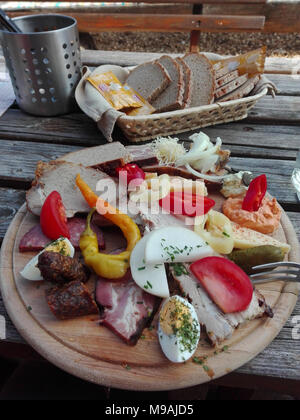 Brettljausn tradizionale con il pane e con un sacco di tagli a freddo sul tavolo di legno in Austria Foto Stock