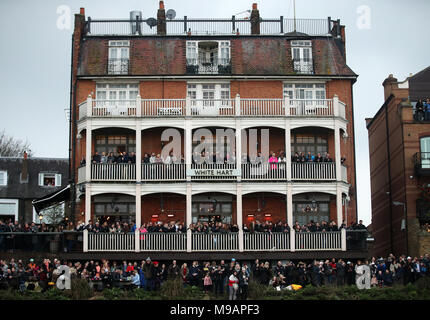 Spettatori guarda l'azione dal White Hart pub di Barnes durante la donna della gara in barca sul fiume Tamigi, Londra. Foto Stock