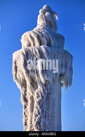 Faro di surgelati e pier su tempestoso giorno d'inverno Foto Stock