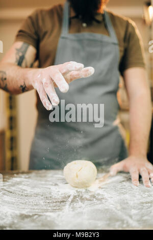 Pasta fresca cucina, cuoco grembiule rende l'impasto Foto Stock