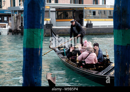 Un gondoliere guide una gondola attraverso il Canal Grande fino al Ponte di Rialto su una piacevole giornata in marzo. Venezia, Italia Foto Stock