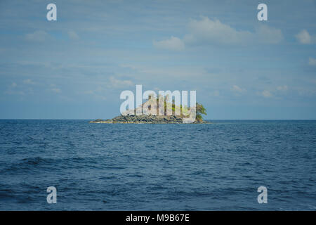 Piccola isola isolata in acque oceaniche - isola tropicale - Foto Stock