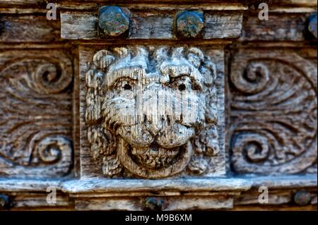 Intaglio del legno di facce su porte medievali Foto Stock