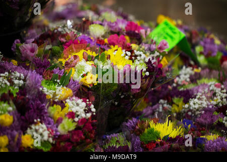 Un assortimento di mazzi di fiori colorati per la vendita in un negozio di fiori. Foto Stock