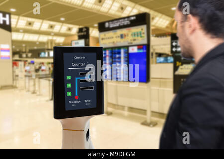 Smart la tecnologia robotica concetto, il passeggero seguire un robot di servizio ad un contatore il check-in in aeroporto, il robot è in grado di aiutare e dare alcune informazioni Foto Stock