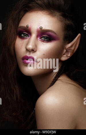 Bruna ragazza con un creative trecce di acconciatura, arte make-up e la Elf le orecchie. Bellezza viso. Foto Stock