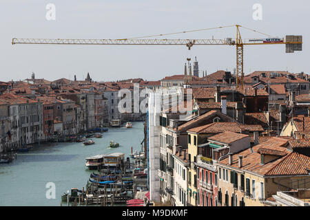 Una gru si siede dietro un edificio vicino al Canal Grande, vista dal Ponte di Rialto di Venezia, Italia Foto Stock