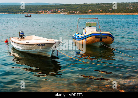 Barche a motore inserito in Dalmazia Sud della Croazia con la piccola barca di persone in background affiancato da riva e boschi Foto Stock