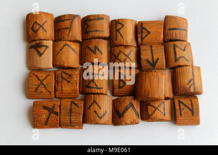 Rune in legno giacciono su una tabella su sfondo bianco Foto Stock