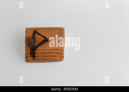 Rune in legno che significa gioia giacciono su una tabella su sfondo bianco Foto Stock