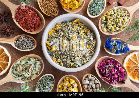 Mix di erbe essiccate su cucchiai di legno, vista dall'alto. Equiseto, Camomilla, Fiordaliso, petali di rose, nasturtium semi, mullein, Alchemilla, TILIA, latte thist Foto Stock