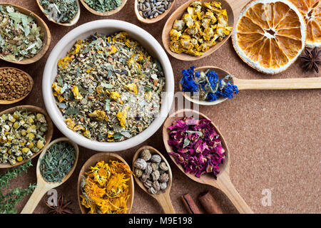 Mix di erbe essiccate su cucchiai di legno con copia spazio, vista dall'alto. Mullein, Fiordaliso, petali di rose, nasturtium semi, calendula, Equiseto, Camomilla, fe Foto Stock