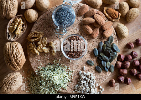 Noci e semi - noci, mandorle, semi di lino, nocciole, la canapa, la zucca e i semi di girasole. Vista dall'alto. Foto Stock