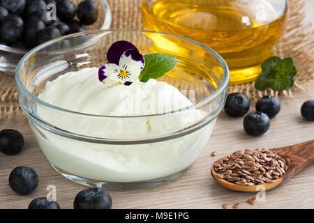 Formaggio con semi di lino, olio di mirtilli, semi di lino e fiori commestibili Foto Stock