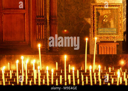 Candele accese di fronte all'icona di Santa Rita da Cascia, il santo patrono di Lost e impossibile provoca, nella chiesa della Madeleine a Parigi Foto Stock