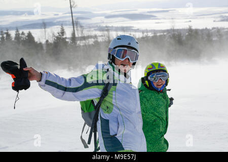 Donna felice e giovane ragazzo in terreno nevoso Foto Stock