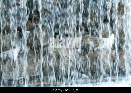 Cascata artificiale spring acqua fluisce nel lago. Foto Stock