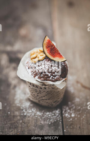 Köstlicher Schokolademuffin auf Holz Hintergrund Foto Stock