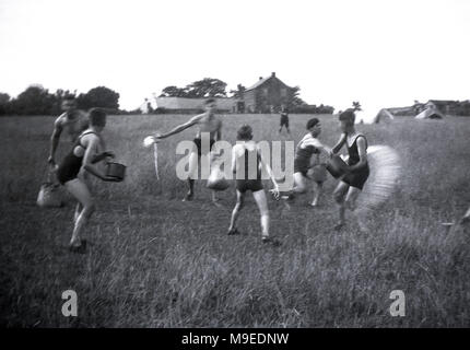 1934, storico, scout camp a Dublino, Irlanda, boy scout al di fuori di divertirsi con acqua di lotta in un campo erboso al loro sito di camp. Foto Stock