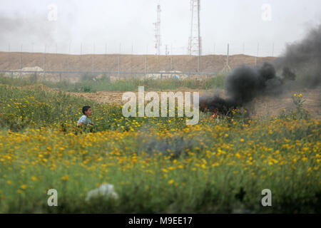 La striscia di Gaza, Territori palestinesi. 23 marzo, 2018. Un dimostranti palestinesi scaglia pietre alle truppe israeliane durante gli scontri con le truppe israeliane nei pressi di Foto Stock