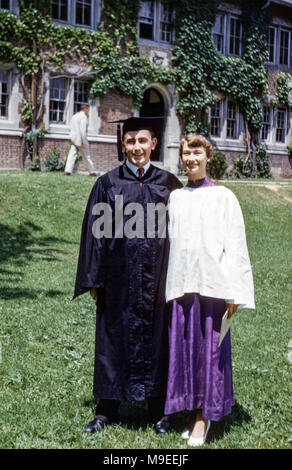 Cerimonia di laurea Hobart e William Smith Colleges, Ginevra, New York, USA. Giovane coppia in abiti di laurea in posa nel Quadrangle fuori Coxe Hall negli anni '50 Foto Stock