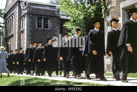 Cerimonia di laurea Hobart e William Smith Colleges, Ginevra, New York, USA. La linea di studenti universitari che camminano sul sentiero nel Quadrangle di fronte alla Coxe Hall, indossando abiti e tavole di Malta nella cerimonia di laurea degli anni 50 Foto Stock