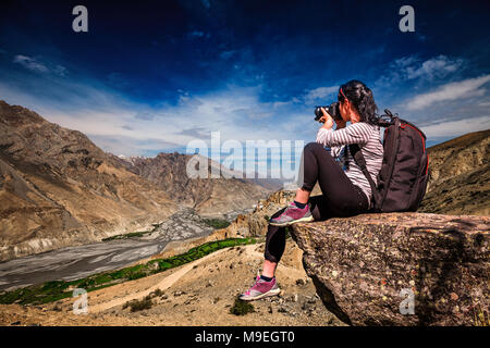 Dhankar gompa. Spiti Valley, Himachal Pradesh, India. Fotografo di natura turistico con fotocamera germogli mentre permanente sulla cima della montagna. Foto Stock