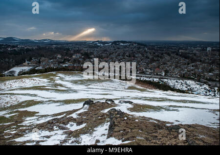 Una vista dall'alto sopra di Edimburgo in half light guardando ad ovest con raggi di luce attraverso la rottura delle pesanti nuvole nere Foto Stock