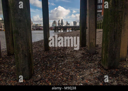 Uno sguardo inusuale o la City di Londra da sotto il pontile in legno presso la Torre di osso su London South Bank Foto Stock