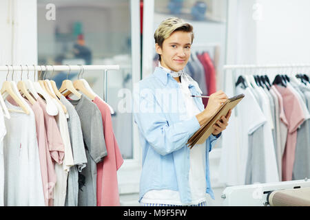 Designer rendendo note in Blocco note nel suo studio Foto Stock