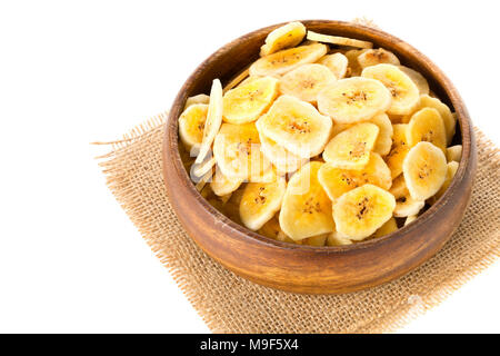 Cumulo di Banane essiccate chips snack in ciotola di legno su tela su sfondo bianco Foto Stock