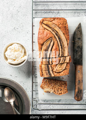 Il burro-libera, senza zucchero pane alla banana con farina di avena, soft cagliata di formaggio e miele. Vista dall'alto di fettine di pane alla banana sul cemento grigio Sfondo. Idee e ricette per la dieta sana prima colazione. Verticale. Foto Stock