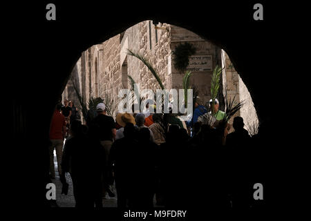 Gerusalemme, Israele 25 marzo. 2018. Christian adoratori holding palms prendendo parte al tradizionale Domenica delle Palme processione lungo la via dolorosa in Gerusalemme la città vecchia, il giorno che segna per i cristiani Gesù Cristo lâ entrata in Gerusalemme quando i suoi seguaci di cui rami di palma nel suo percorso, prima della sua crocifissione e segna l'inizio della Settimana Santa, che termina sulla Pasqua. Foto Stock