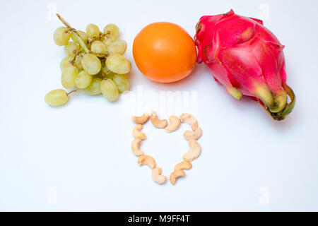 Frutta esotica. Layout creativo fatto di , Arancia, papaia, dragon frutta, uva, anacardi. Lay piatto. Concetto di cibo. Foto Stock