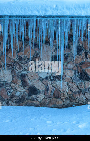 Ghiaccioli sul tetto di un edificio in Lake Tahoe, California, durante l'inverno. Foto Stock