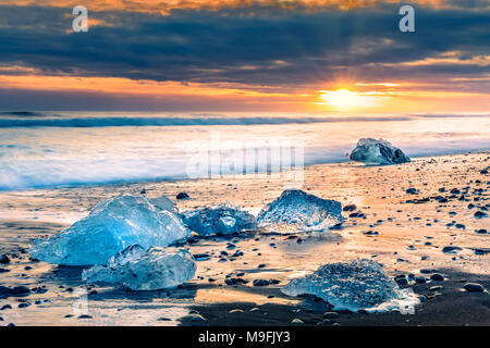 Il drifting blocchi di ghiaccio sulla spiaggia di diamante, al tramonto, in Jokulsarlon, Islanda Foto Stock