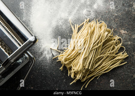 La pasta italiana i tagliolini al tartufo e pasta maker. Foto Stock