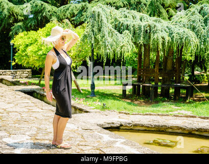 Felice bella donna sta godendo di giorno di estate in un giardino Foto Stock