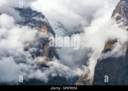 Montagne di nuvole basse in sera Nuvoloso in Nepal. Paesaggio con belle e alte rocce e drammatico cielo nuvoloso al tramonto. La natura dello sfondo. Fairy Foto Stock