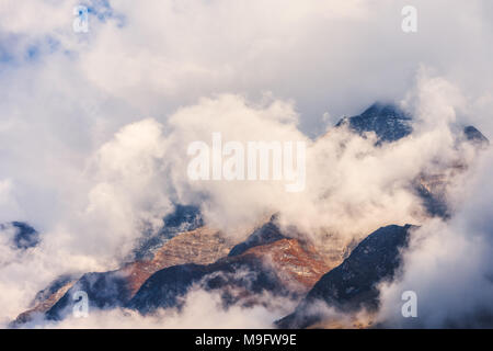 Montagne di nuvole nel cielo coperto sera in Nepal. Paesaggio con belle e alte rocce e drammatico cielo nuvoloso al tramonto. La natura dello sfondo. Fairy scen Foto Stock